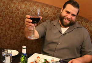villa capri poway owner sitting at table holding wine glass